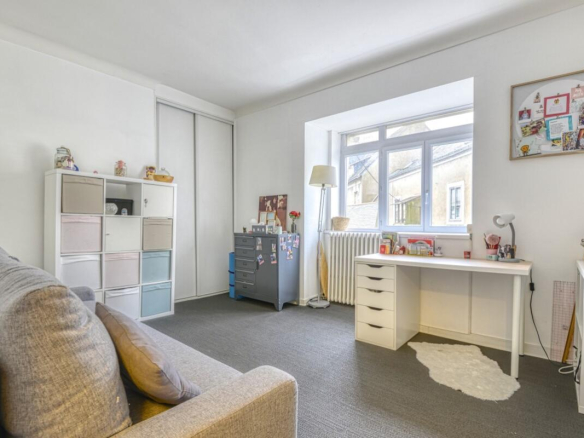 Interior of an apartment in Nantes with a desk area and a sofa, natural light.