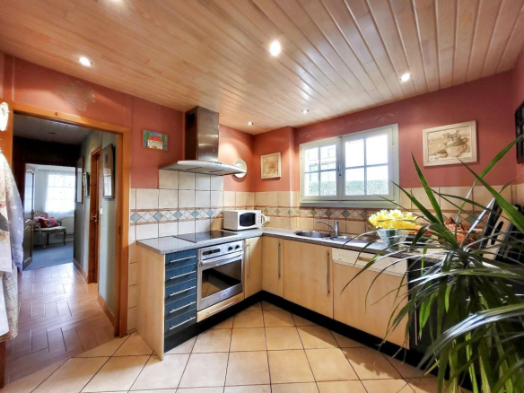 Kitchen of a traditional chalet in Grilly, with wooden furniture and a tiled worktop.