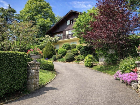 Large traditional chalet in Grilly with landscaped garden and access driveway.