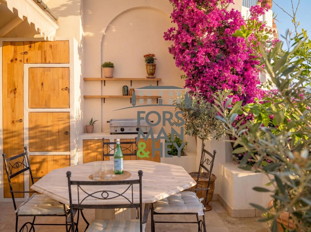 Terrace of an apartment in Grasse Terrace of an apartment in Grasse with table and chairs, surrounded by flowers and wooden elements.