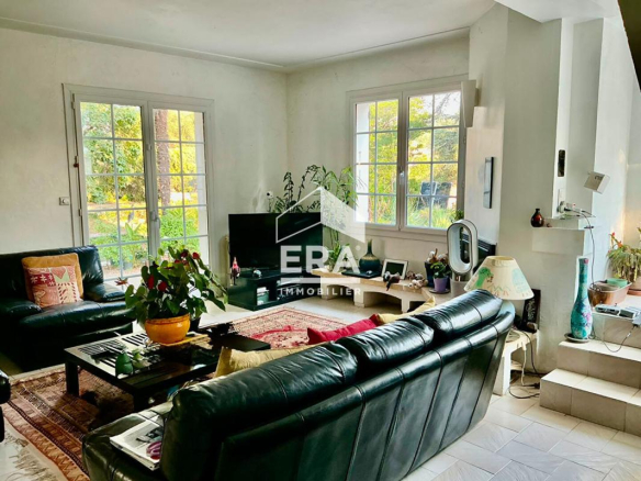 Interior of a 1960s house with a bright living room, leather sofas and large windows.