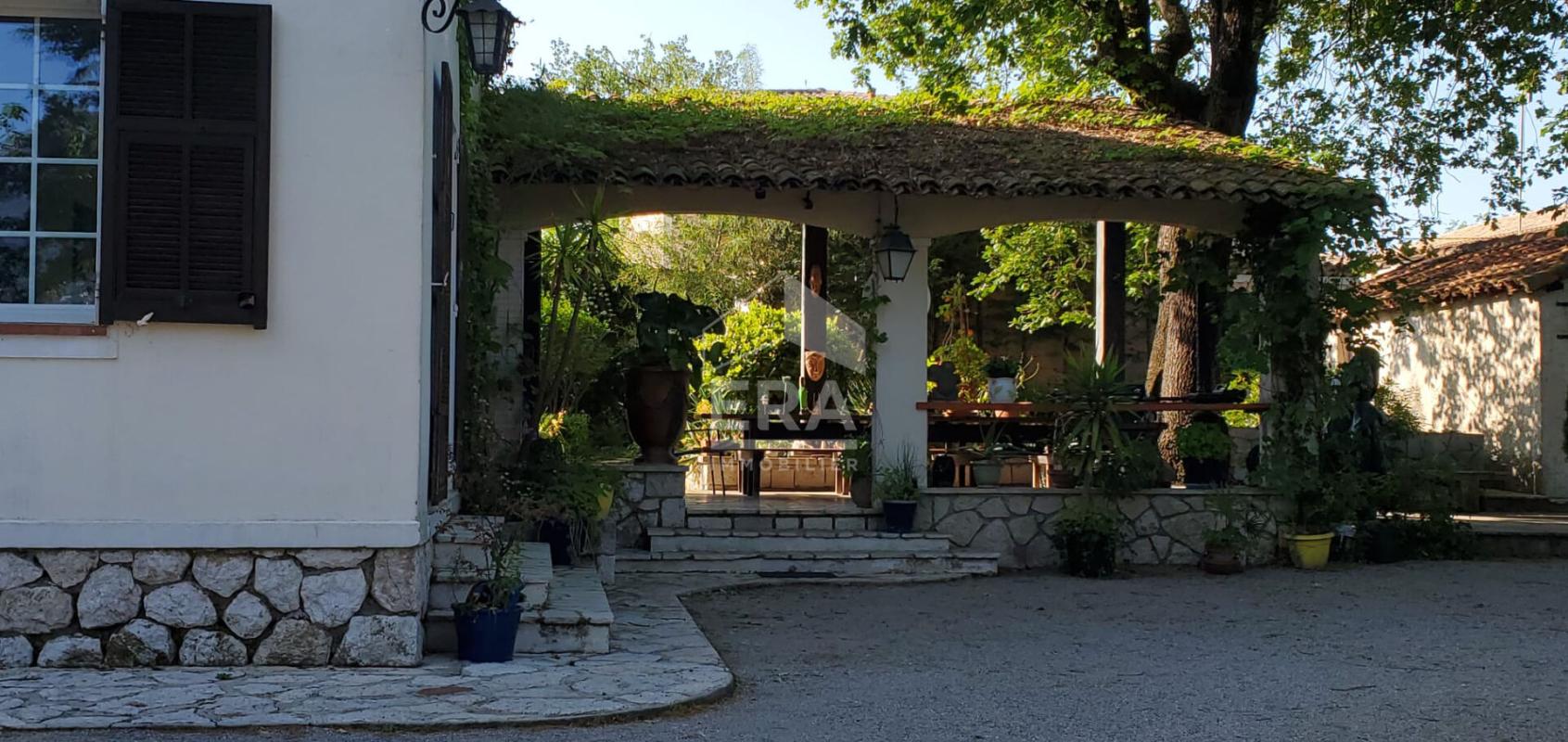 Exceptional House in La Gaude Entrance to a 1960s house with a covered terrace and a green garden in La Gaude.