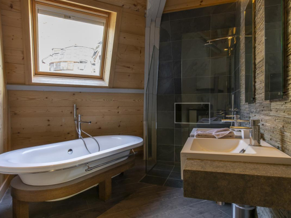 Salle de bain moderne avec baignoire, lavabo et douche dans un chalet à Avoriaz.