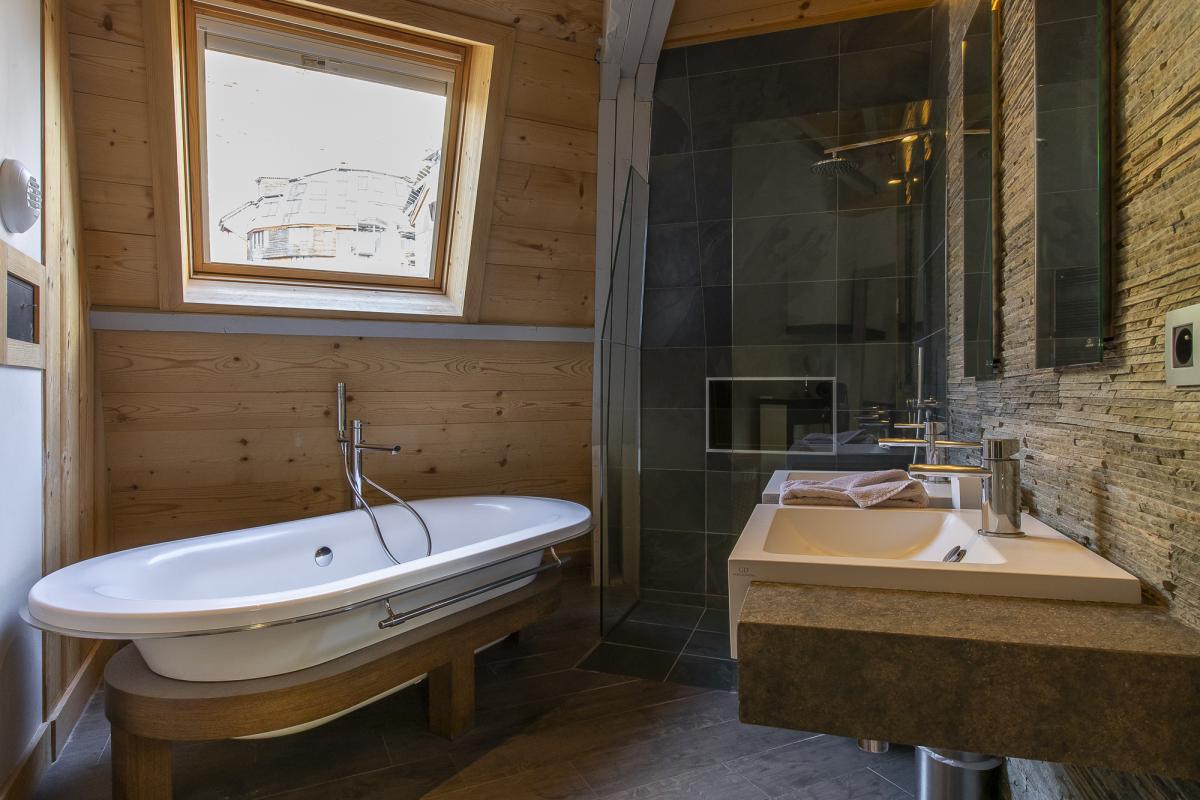 Salle de bain du Chalet ALAYA NOA Salle de bain moderne avec baignoire, lavabo et douche dans un chalet à Avoriaz.