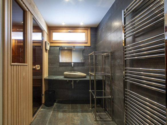 Salle de bain moderne avec sauna et espace de rangement dans un chalet.