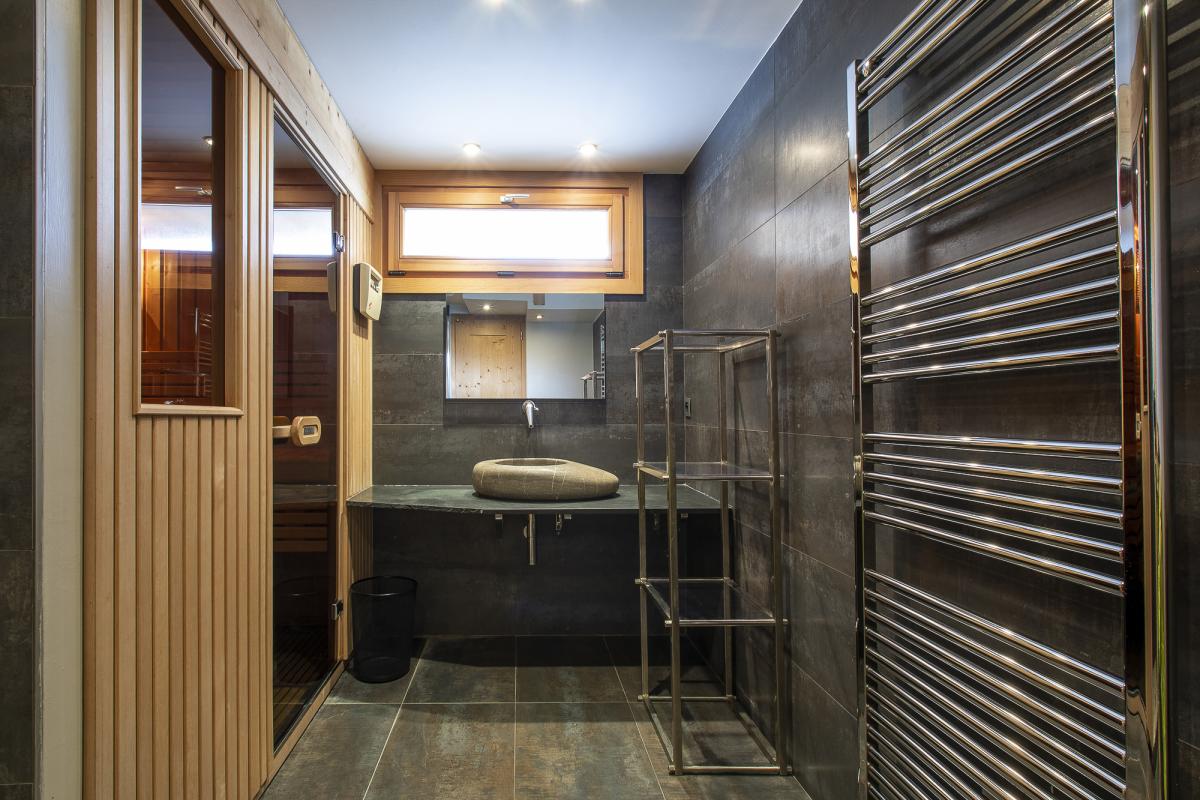 Salle de bain du chalet ALAYA NOA Salle de bain moderne avec sauna et espace de rangement dans un chalet.