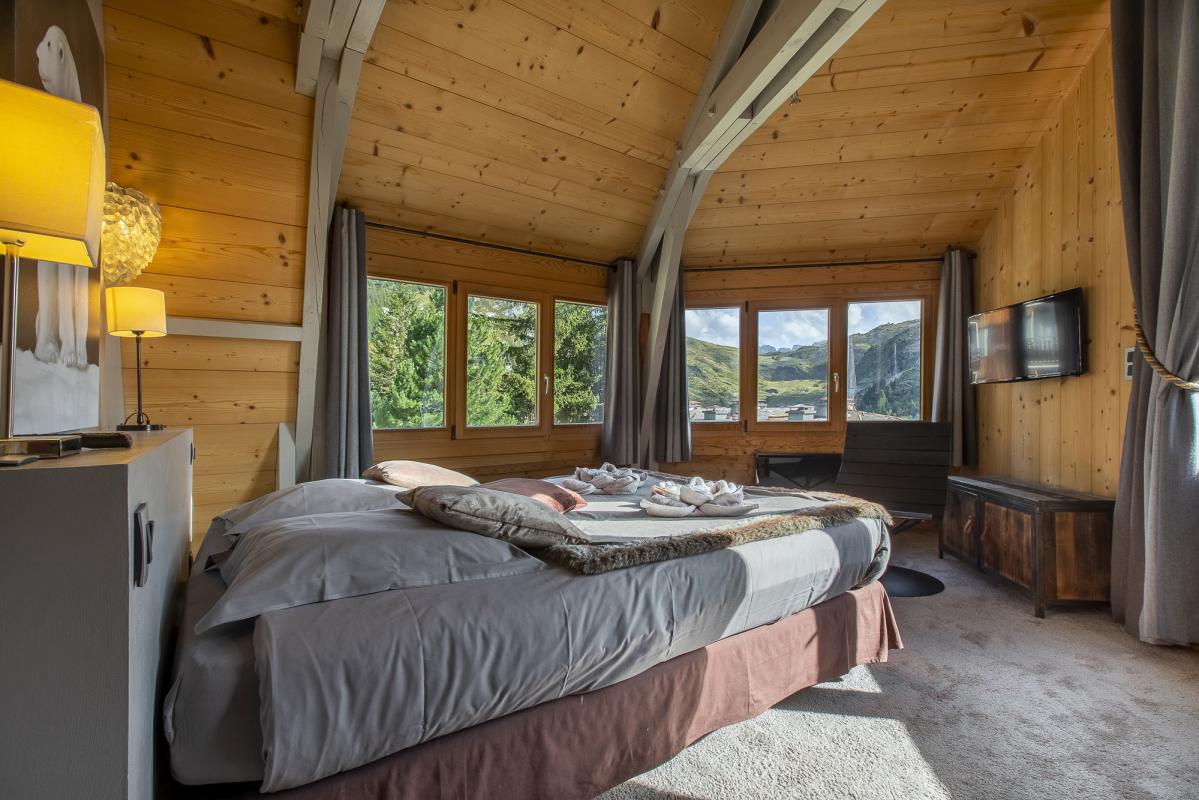 Chambre du Chalet ALAYA NOA Chambre d'un chalet avec lit double, fenêtres panoramiques et décoration en bois à Avoriaz.