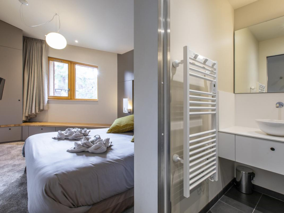 Chambre moderne avec lit double et salle de bain attenante dans un chalet à Avoriaz.