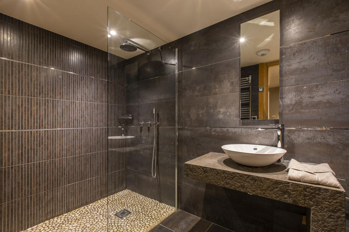 Salle de bain du chalet ALAYA ALBA Salle de bain moderne avec douche en verre et lavabo design dans un chalet.