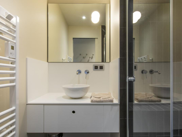Salle de bain moderne avec douche, lavabo et miroir, dans un chalet à Morzine.