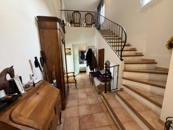 Intérieur d'une villa à Puget-sur-Argens avec un hall d'entrée et un escalier en colimaçon.