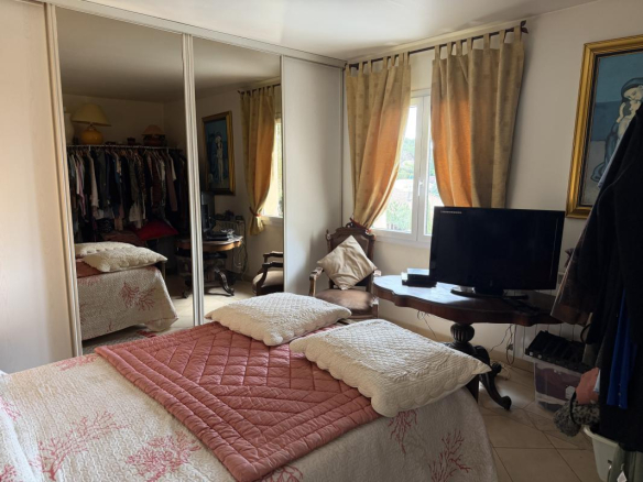 Chambre d'une villa à Puget-sur-Argens avec lit, télévision et placard.