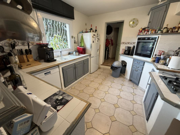 Cuisine d'une villa à Puget-sur-Argens, avec meubles gris et carrelage clair.