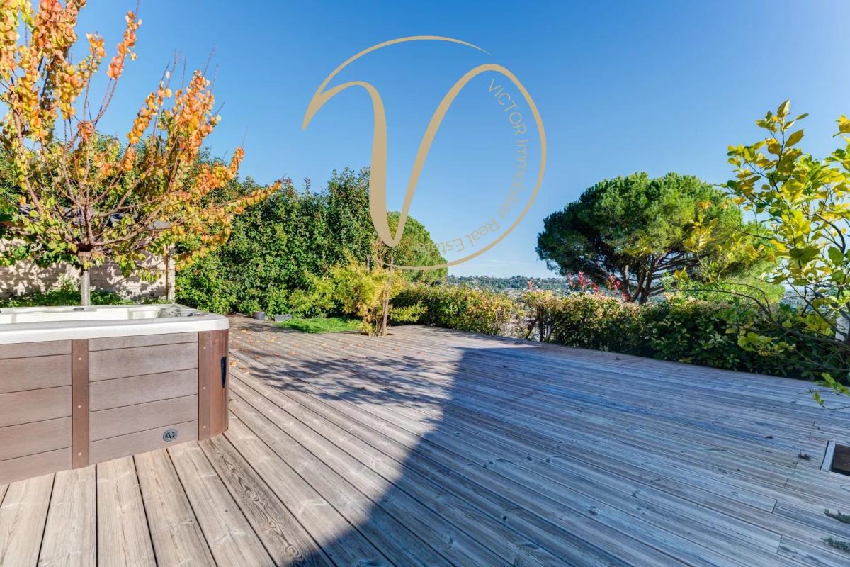 Terrace with jacuzzi and view Wooden terrace with jacuzzi, views of hills and sea, surrounded by vegetation.
