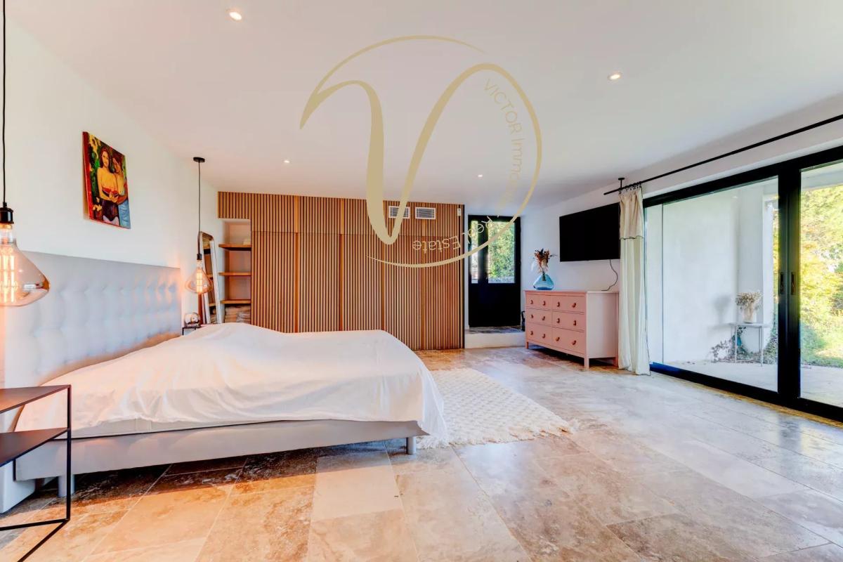 Contemporary villa bedroom Modern room with bed, parquet flooring and access to the outside in a contemporary villa.