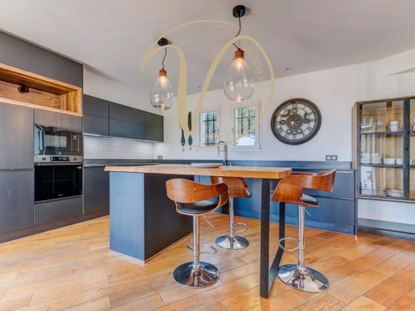 Modern kitchen with central island and bar, pendant lighting, and wood and black furniture.
