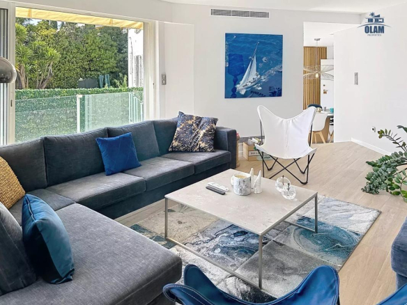 Intérieur d'une villa à Cannes avec salon moderne, canapé gris et décoration élégante.