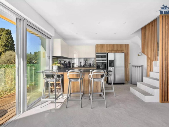Cuisine moderne avec bar et accès à l'extérieur dans une villa à Cannes.