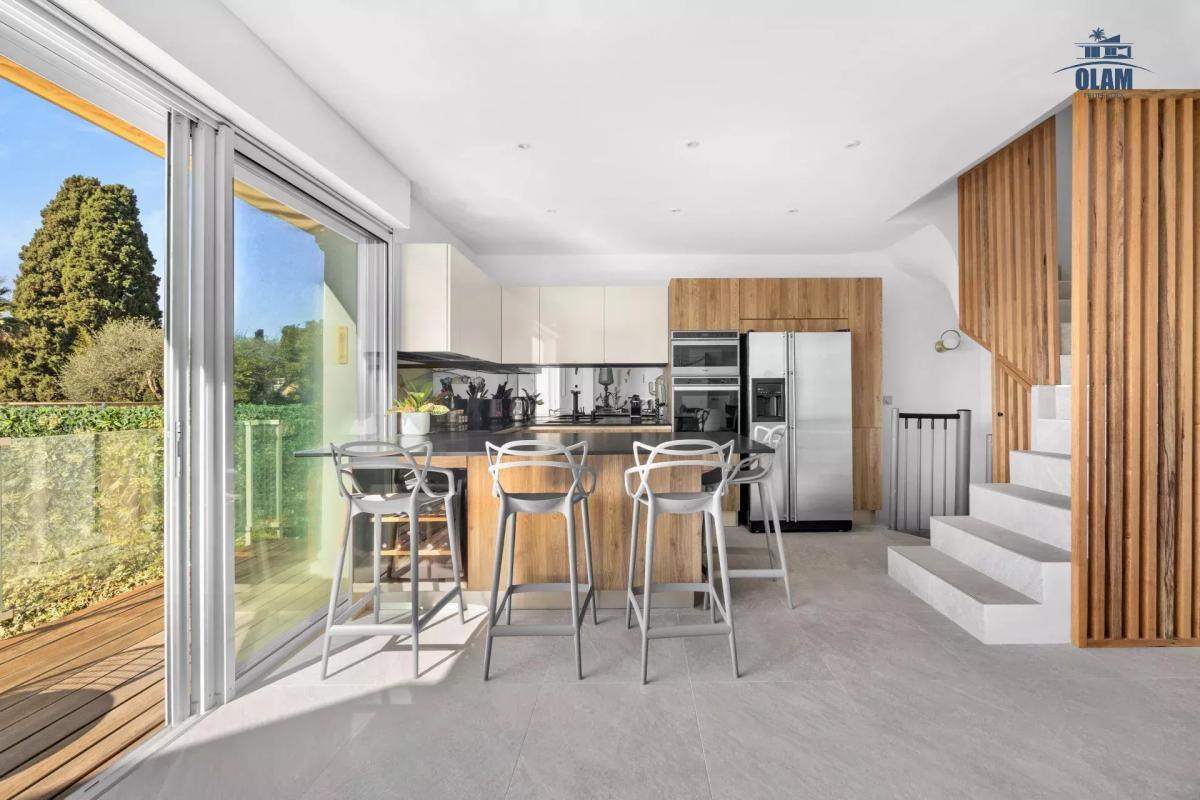 Cuisine moderne avec bar et accès à l'extérieur dans une villa à Cannes.