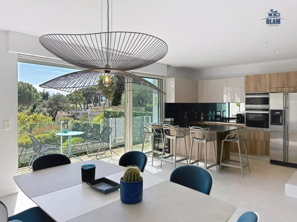 Intérieur moderne d'une villa à Cannes avec cuisine ouverte et vue sur le jardin.
