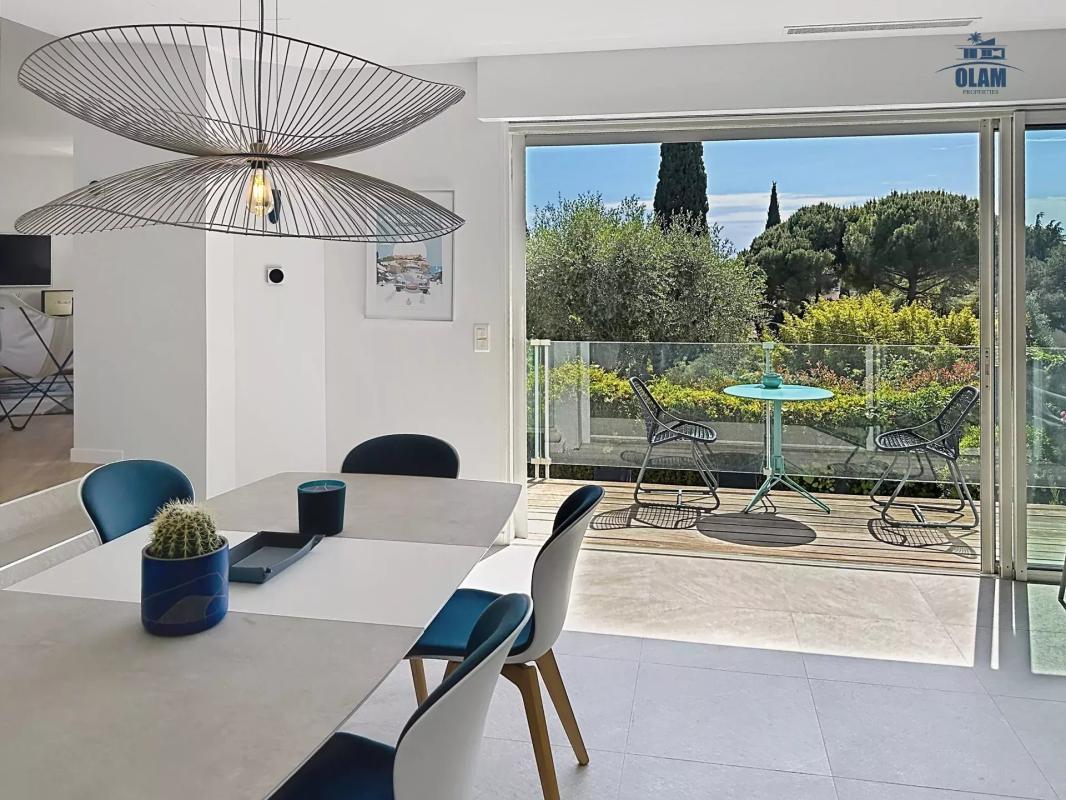 Salle à manger moderne avec vue sur un balcon et un jardin à Cannes.