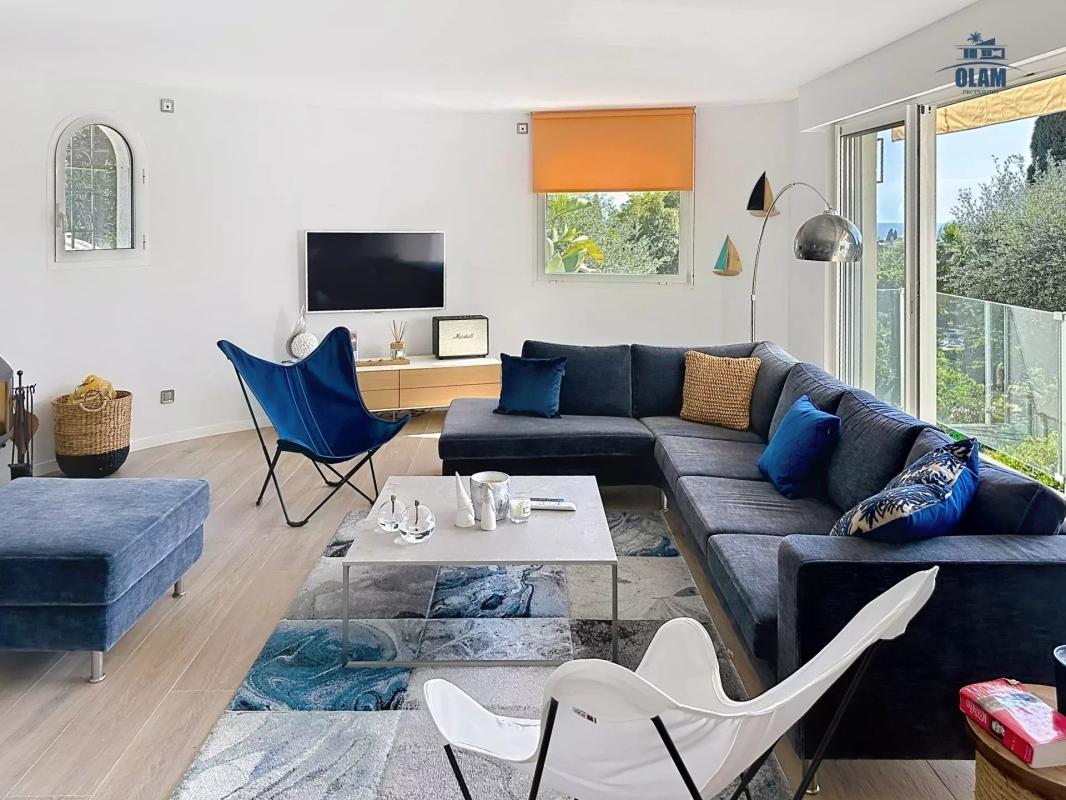 Intérieur moderne d'une villa à Cannes avec salon lumineux et vue sur la mer.