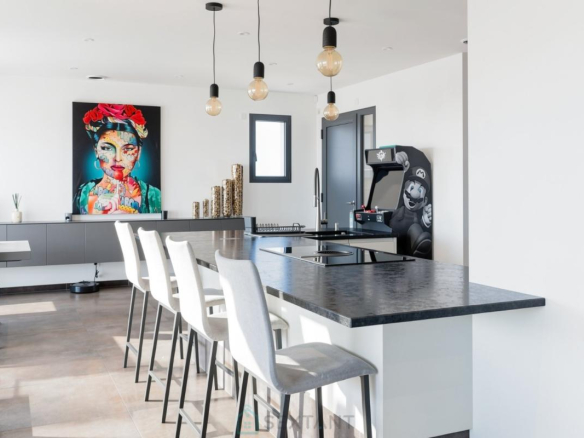 Intérieur d'une villa contemporaine avec cuisine moderne et décoration artistique.