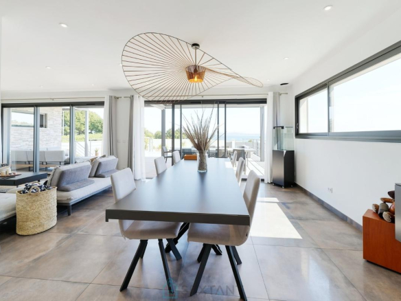 Intérieur d'une villa contemporaine à Istres, avec salle à manger et salon lumineux.