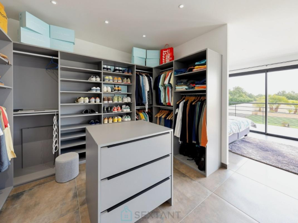 Intérieur d'un dressing moderne avec vêtements et chaussures, lumière naturelle