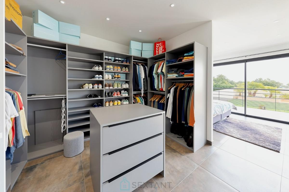 Dressing contemporain Intérieur d'un dressing moderne avec vêtements et chaussures, lumière naturelle
