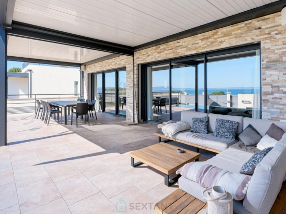 Terrasse d'une villa contemporaine avec vue sur la mer à Istres, mobilier moderne et espace de vie extérieur.