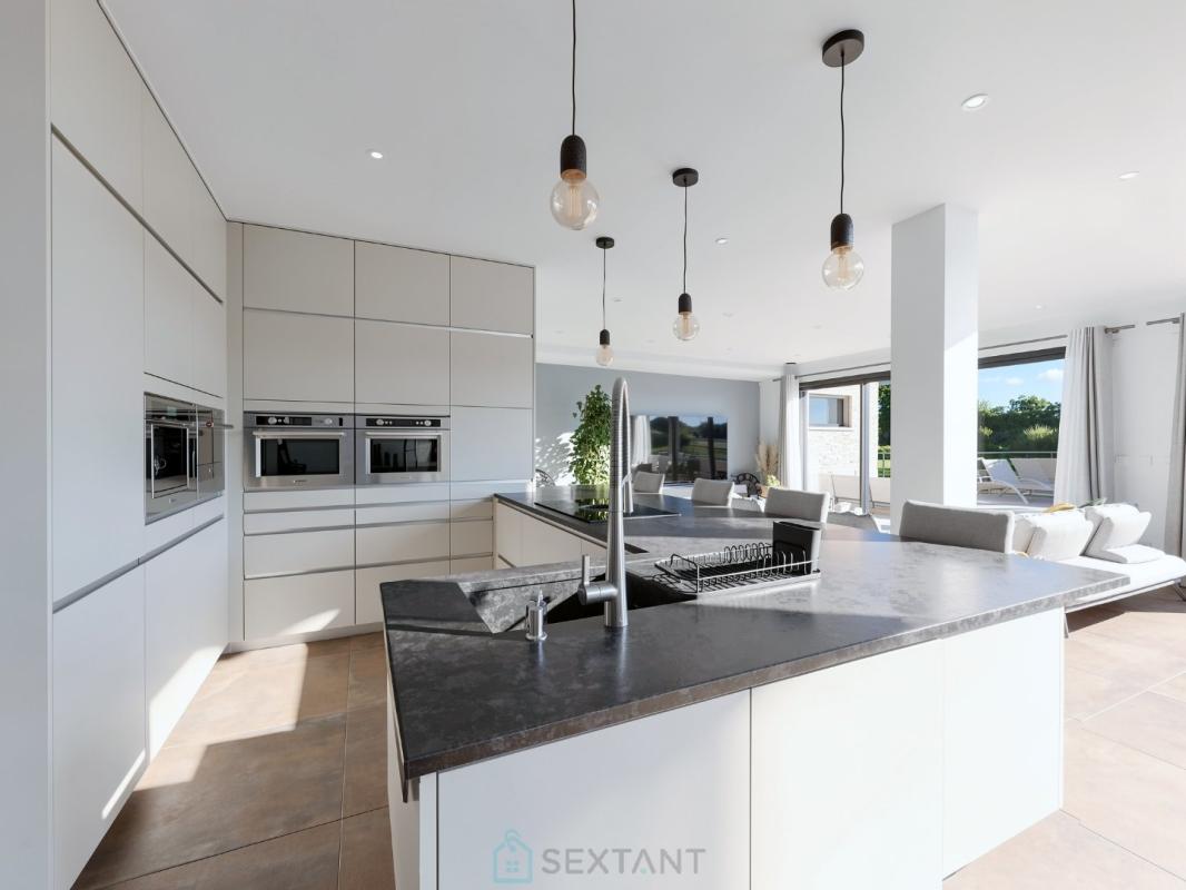 Cuisine d’une villa d’architecte à Istres Cuisine moderne d'une villa contemporaine avec îlot central et grandes fenêtres