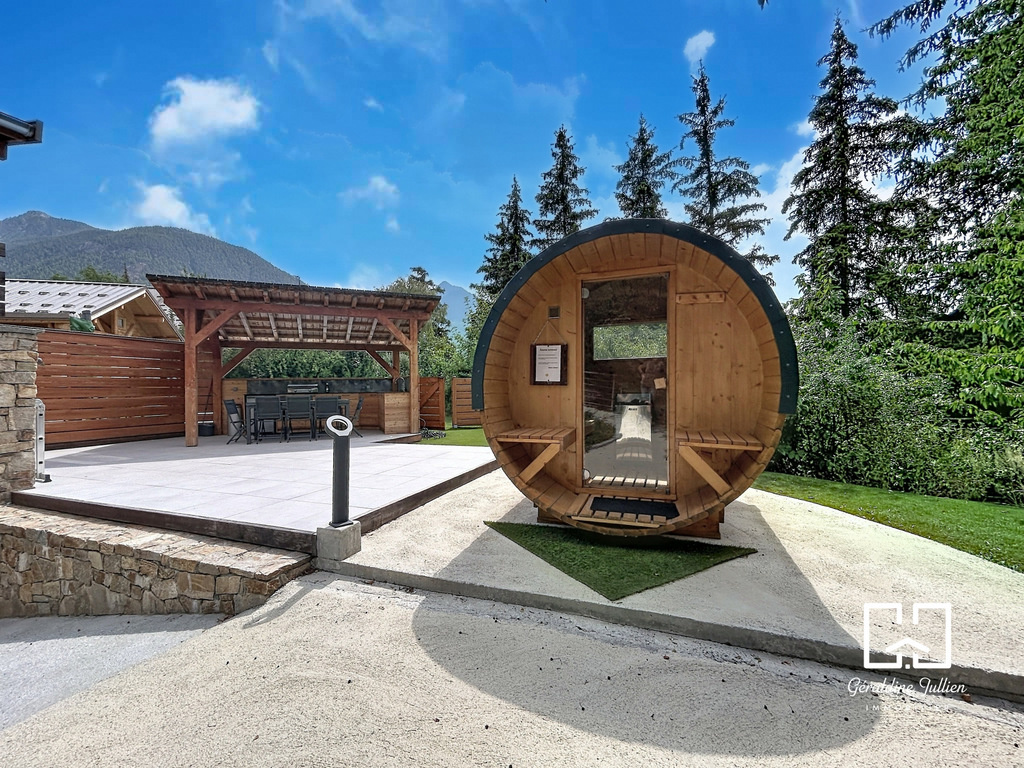 Maison avec piscine à Briançon Espace extérieur d'une maison avec piscine à Briançon, incluant un sauna en bois et une terrasse.