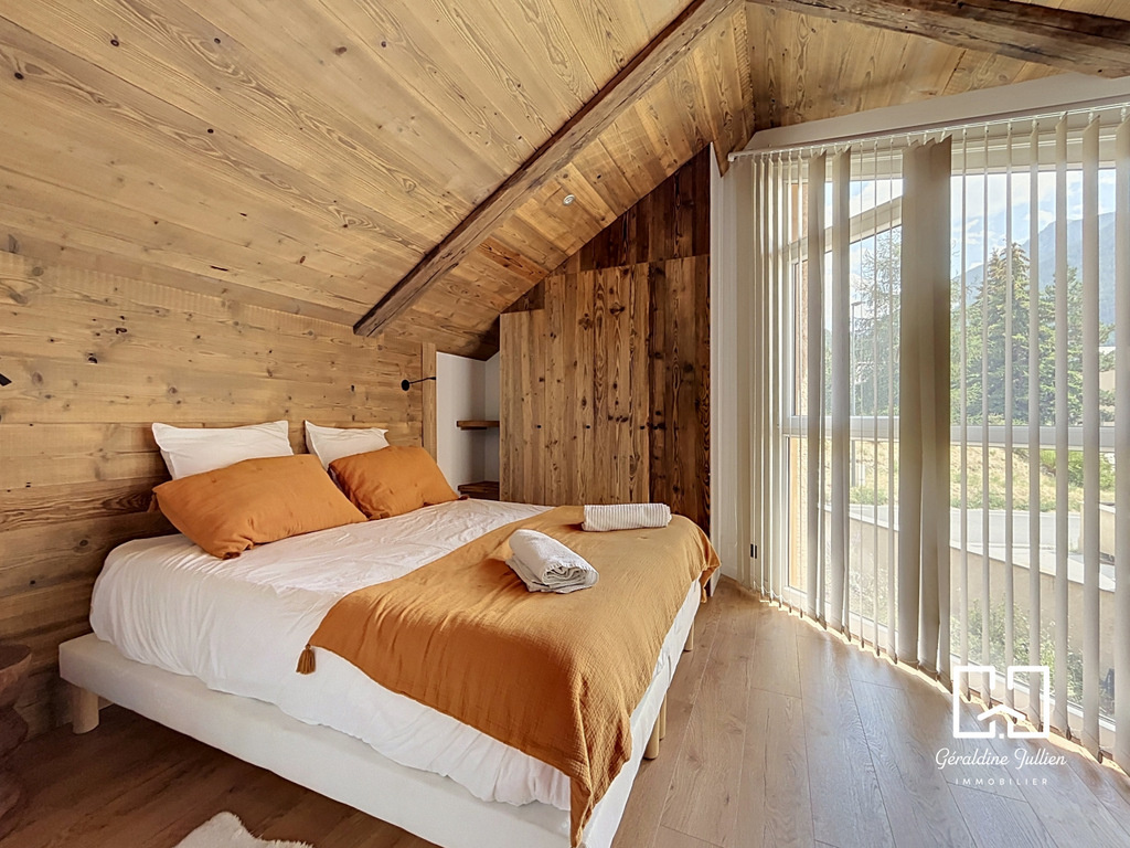 Chambre moderne à Briançon Chambre à coucher avec lit double et vue sur l'extérieur, décorée en bois à Briançon.