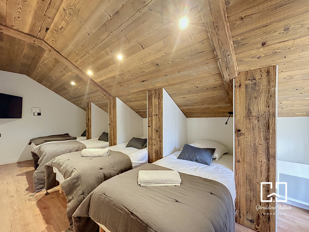 Chambre dans une maison rénovée à Briançon Chambre avec lits simples et plafond en bois dans une maison rénovée à Briançon.