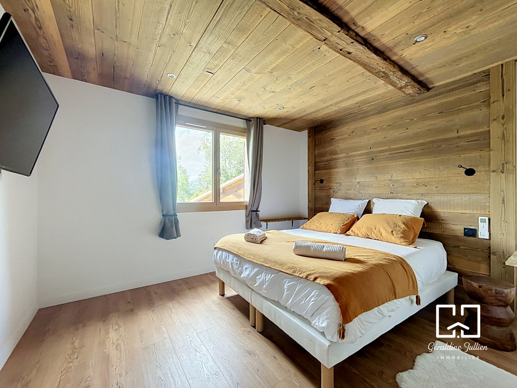 Chambre rénovée à Briançon Chambre d'une maison rénovée à Briançon avec lit double et décoration en bois.