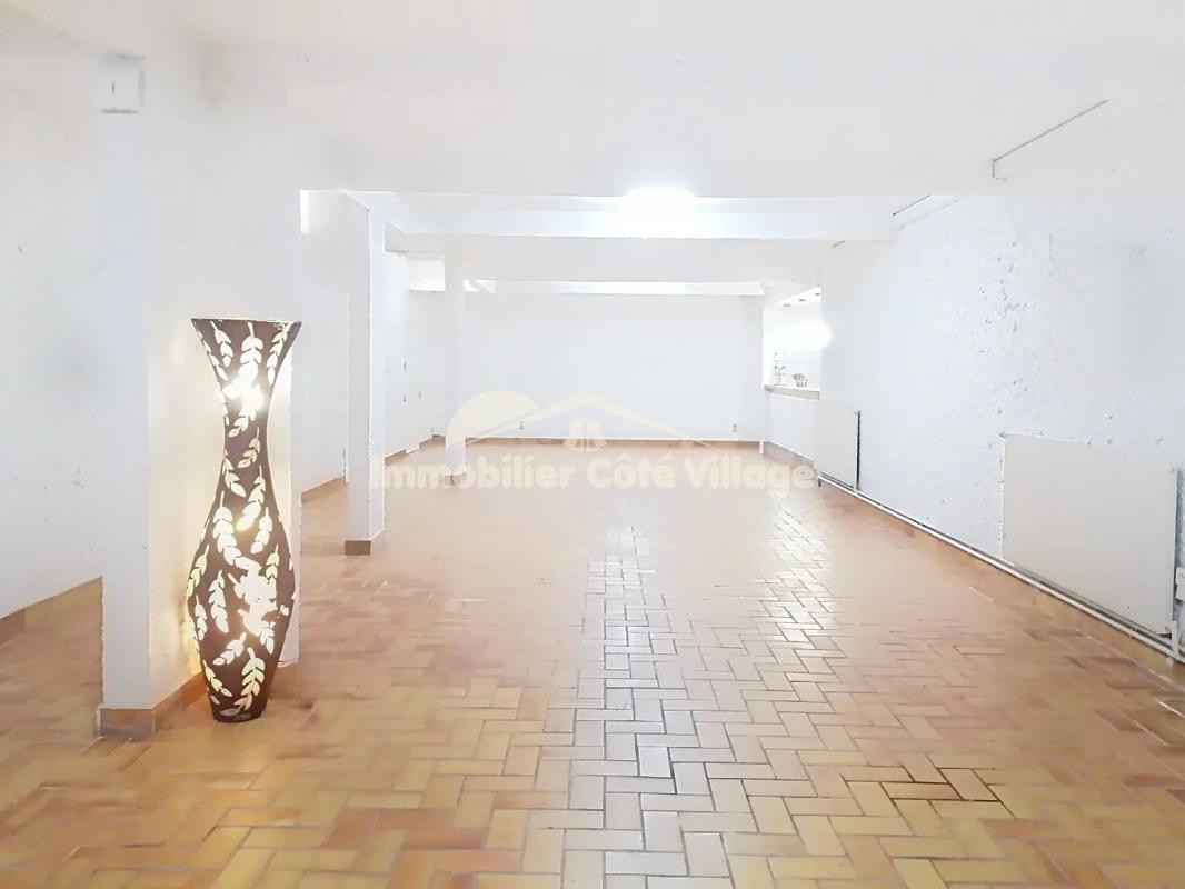 Intérieur spacieux d'une propriété à Drap avec un sol en carrelage et un éclairage décoratif.