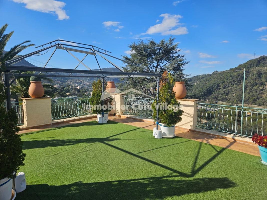 Terrasse verdoyante avec vue panoramique sur les collines de Drap, près de Nice.