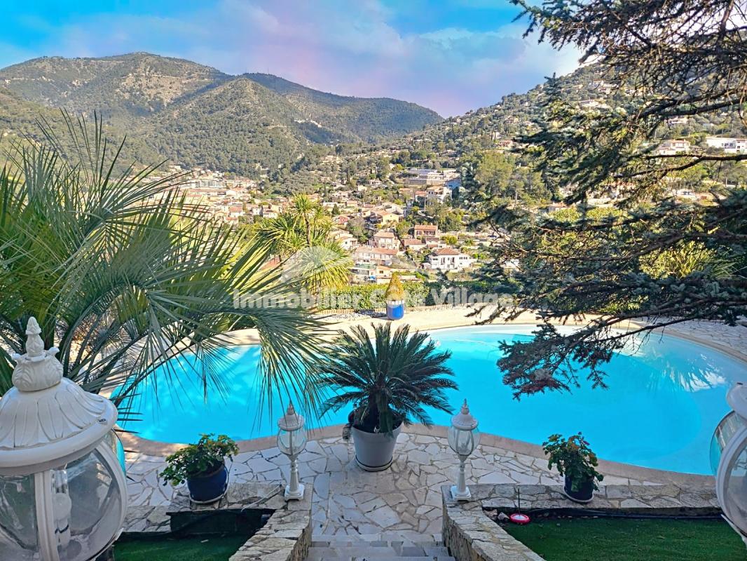 Vue panoramique sur une propriété avec piscine et végétation, située sur les collines de Drap près de Nice.