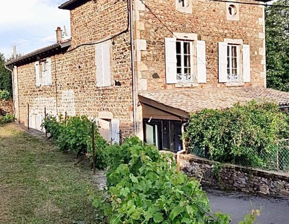 Maison en pierre rénovée à Beaujeu, avec jardin arboré et environnement calme.