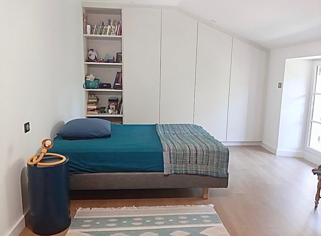 Chambre d'une maison rénovée à Beaujeu avec lit et rangement