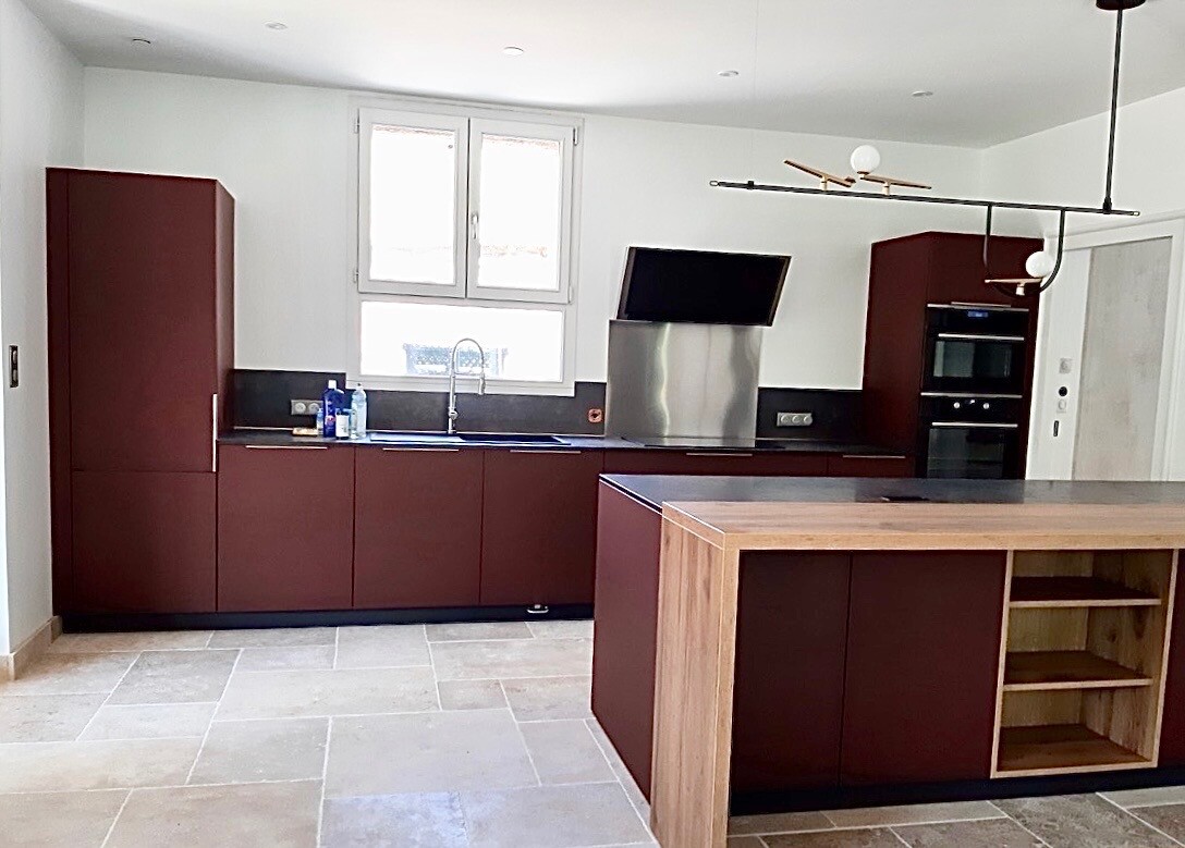 Cuisine moderne et spacieuse d'une maison rénovée à Beaujeu, avec des meubles en bois et des appareils électroménagers intégrés.
