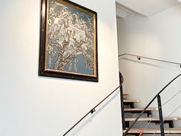 Escalier moderne avec une œuvre d'art encadrée sur le mur.