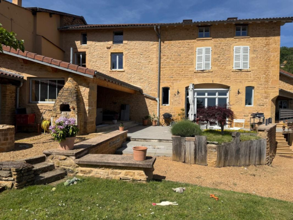Maison en pierre avec terrasse et jardin à Ville-sur-Jarnioux, vue dégagée.