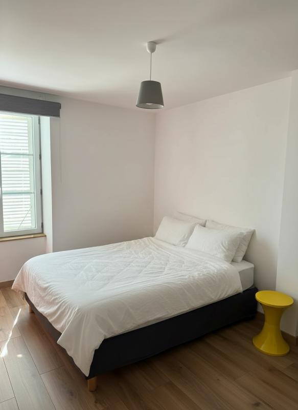 Chambre d’une maison à Ville-sur-Jarnioux Chambre avec lit double et table de chevet jaune dans une maison à Ville-sur-Jarnioux.