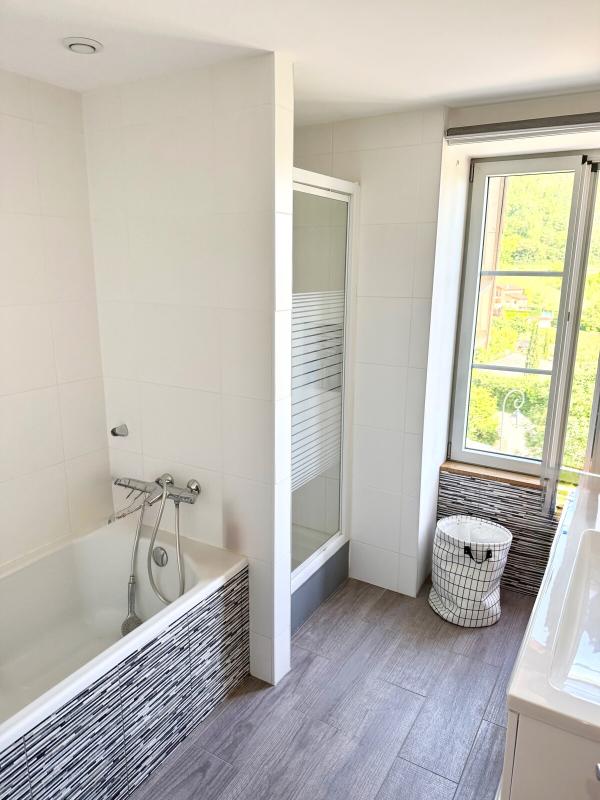 Salle de bain contemporaine Salle de bain moderne avec baignoire, douche et fenêtre laissant entrer la lumière naturelle.