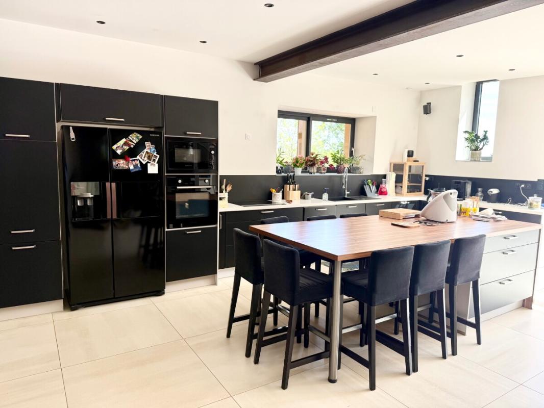 Cuisine spacieuse et moderne Cuisine moderne avec îlot central et équipements complets dans une maison à Ville-sur-Jarnioux.