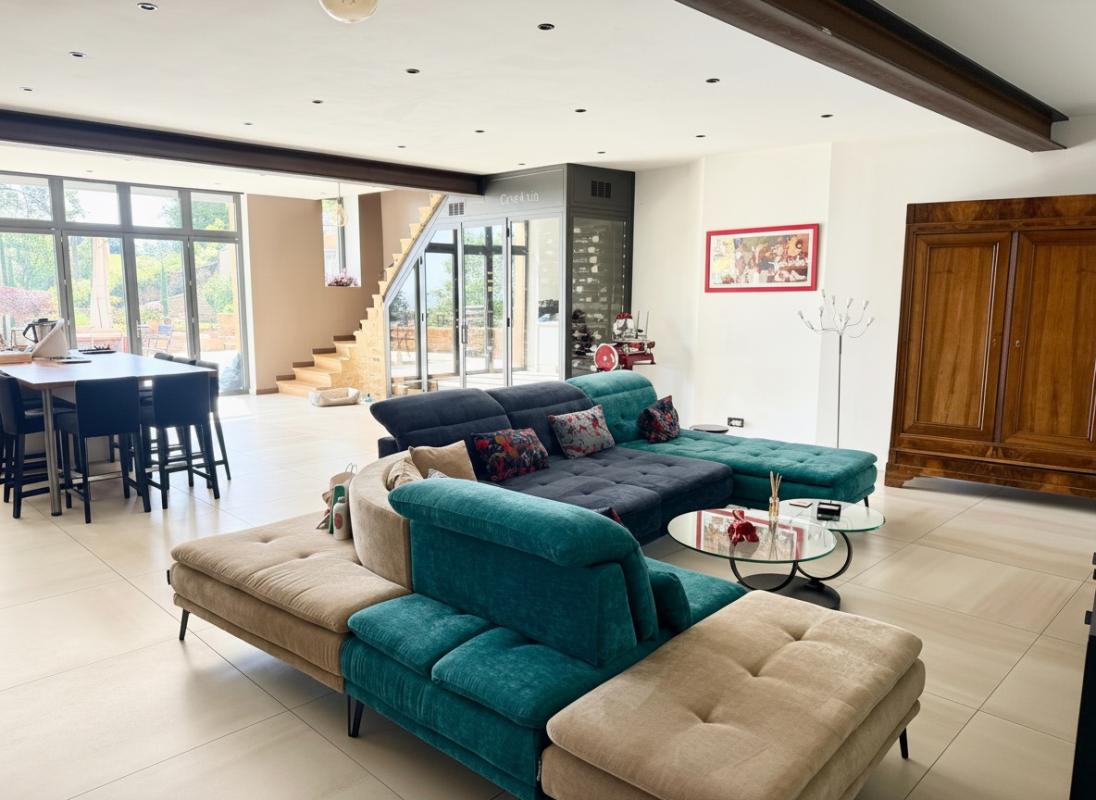 Intérieur d’une maison à Ville-sur-Jarnioux Intérieur d'une maison moderne avec salon spacieux et cuisine ouverte à Ville-sur-Jarnioux.