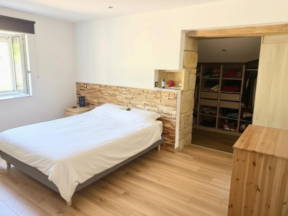 Chambre d'une maison à Ville-sur-Jarnioux, avec lit double et rangement intégré.