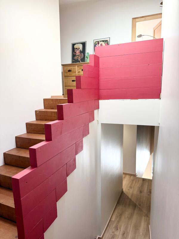 Escalier intérieur moderne Escalier moderne avec rambarde rose et murs blancs, intérieur d'une maison à Ville-sur-Jarnioux.